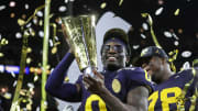 Michigan defensive back Mike Sainristil lifts the trophy to celebrate the 34-13 win over Washington