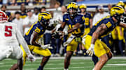 Michigan quarterback Alex Orji (10) hands the ball to Michigan running back Kalel Mullings (20) during the first half against Fresno State at Michigan Stadium at Michigan Stadium in Ann Arbor on Saturday, Aug. 31, 2024.