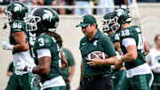 Michigan State's head coach Jonathan Smith holds a football as the team warms up before the game against Youngstown State on Saturday, Sept. 13, 2025, at Spartan Stadium in East Lansing.