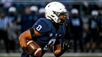 East Lansing's Jace Clarizio runs for a gain against DeWitt during the first quarter on Friday, Sept. 27, 2024, at East Lansing High School.