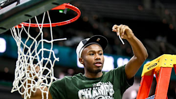 Michigan State's Tre Holloman shows off a piece of the net he helped cut down while the Spartans celebrate the Big Ten title after the game against Michigan on Sunday, March 9, 2025, at the Breslin Center in East Lansing.