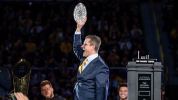 Michigan head coach Jim Harbaugh lifts the AFCA Coaches' Trophy during the national championship celebration at Crisler Center in Ann Arbor on Saturday, Jan. 13, 2024.