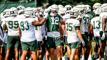 Michigan State's Jack Velling, right, high fives Jalen Satchell during the first day of football camp on Tuesday, July 30, 2024, in East Lansing.