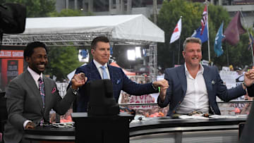 Desmond Howard, left, Rece Davis, and Pat McAfee hold hands for a photo before starting live broadcast during ESPN Gameday near Williams-Brice Stadium in Columbia, S.C. Saturday, September 14, 2024.