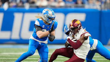 Detroit Lions linebacker Alex Anzalone (34) and Detroit Lions cornerback Terrion Arnold (0) take down Washington Commanders wide receiver Terry McLaurin (17) in the NFC divisional round at Ford Field in Detroit on Saturday, Jan. 18, 2025.