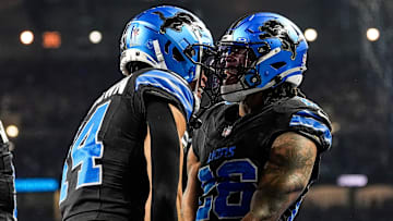 Detroit Lions running back Jahmyr Gibbs (26), right, celebrates a touchdown against Minnesota Vikings with wide receiver Amon-Ra St. Brown (14) during the first half at Ford Field in Detroit on Sunday, Jan. 5, 2025.