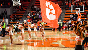 A Clemson cheerleader runs a flag by other cheerleaders during the second half at Littlejohn Coliseum Thursday, November 21, 2024; Clemson, SC, USA.