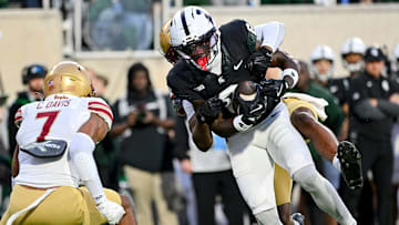 Michigan State's Nick Marsh, right, carries Boston College's Amari Jackson on his back as he powers his was into the end zone for a touchdown during the first quarter on Saturday, Sept. 6, 2025, at Spartan Stadium in East Lansing. Boston College's Carter Davis, left, closes in on the play.