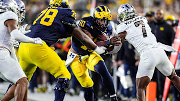 Michigan quarterback Alex Orji (10) runs against Oregon defensive end Matayo Uiagalelei (10) during the second half at Michigan Stadium in Ann Arbor on Saturday, Nov. 2, 2024.