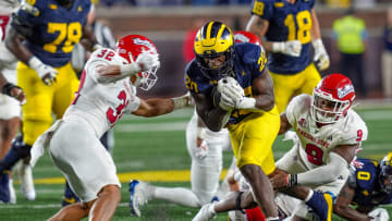 Michigan running back Kalel Mullings (20) runs in between Fresno State defensive back Dean Clark (32) and Fresno State linebacker Malachi Langley (9) during the second half at Michigan Stadium in Ann Arbor on Saturday, Aug. 31, 2024.