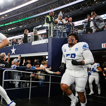 Detroit Lions offensive tackle Penei Sewell follows quarterback Jared Goff.