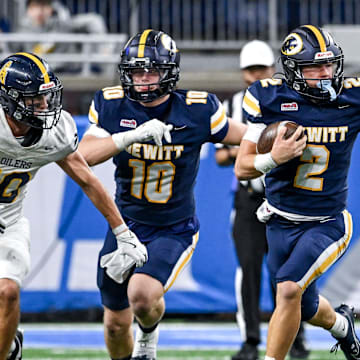 DeWitt's Traverse Moore, right, runs for a gain against Mount Pleasant during the second quarter in the Division 3 football state final on Sunday, Nov. 30, 2025, at Ford Field in Detroit.