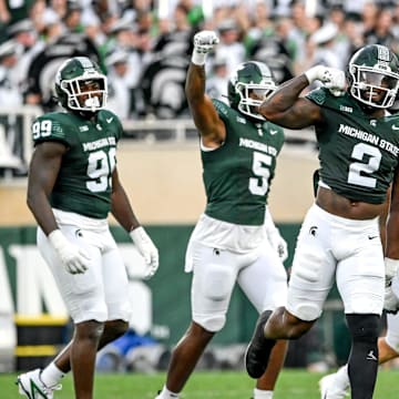 Michigan State's Khris Bogle, center, celebrates his stop against Florida Atlantic during the first quarter on Friday, Aug. 30, 2024, at Spartan Stadium in East Lansing.