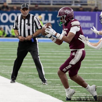 Harper Woods' Dakota Guerrant keeps both feet in bounds as Grand Rapids South Christian's Tanner Raak defends during the MHSAA Division 4 high school football state championship game at Ford Field in Detroit on Saturday, November 25, 2023.
