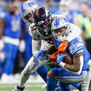 Detroit Lions running back David Montgomery runs against Denver Broncos safety Justin Simmons during the first half at Ford Field in Detroit on Saturday, Dec. 16, 2023.