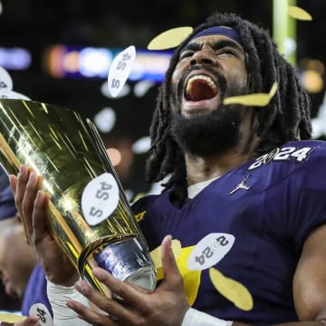 Michigan running back Donovan Edwards lifts the trophy to celebrate the 34-13 win over Washington in the national championship game at NRG Stadium in Houston on Monday, Jan. 8, 2024.
