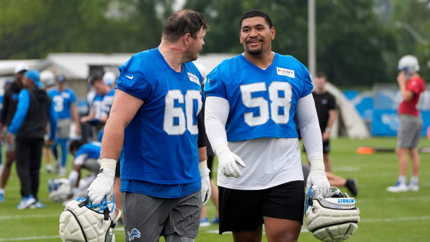 Detroit Lions Graham Glasgow and Penei Sewell talk while heading off the practice field  