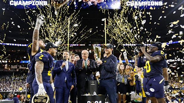 Michigan head coach Jim Harbaugh lifts the trophy to celebrate the 34-13 win over Washington to win the national championship