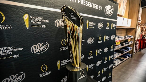 Fans stop to take photos with the College Football National Championship trophy at Meijer in Ypsilanti, Mich