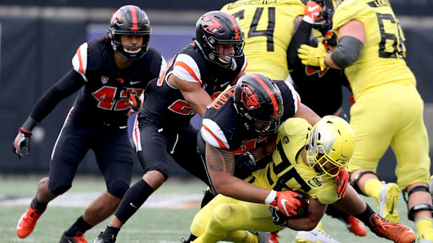 Oregon's Travis Dye (26) is taken down in the Oregon vs. Oregon State Civil war football game at Oregon State University