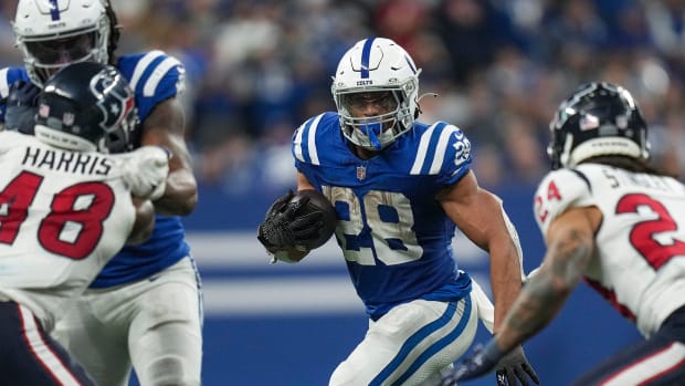 Football player Jonathan Taylor runs with the ball in a blue jersey.