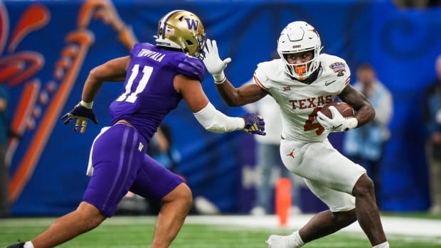 Texas Longhorns running back CJ Baxter (4) braces as Washington Huskies linebacker Alphonzo Tuputala (11) goes for the tackle