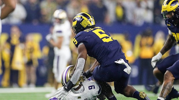 Michigan defensive end Josaiah Stewart tackles Washington quarterback Michael Penix Jr. during the first half of the national