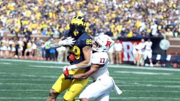 Michigan tight end AJ Barner makes a catch against Rutgers linebacker Deion Jennings during the