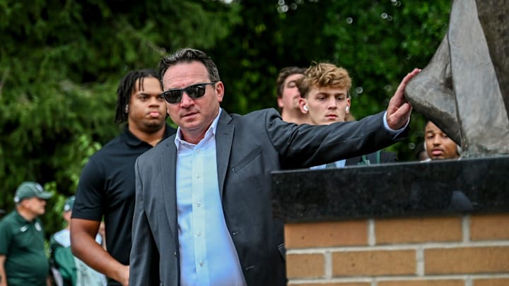 Michigan State's head coach Jonathan Smith touches the foot of the Sparty statue before the game against Florida Atlantic on Friday, Aug. 30, 2024, outside Spartan Stadium in East Lansing.