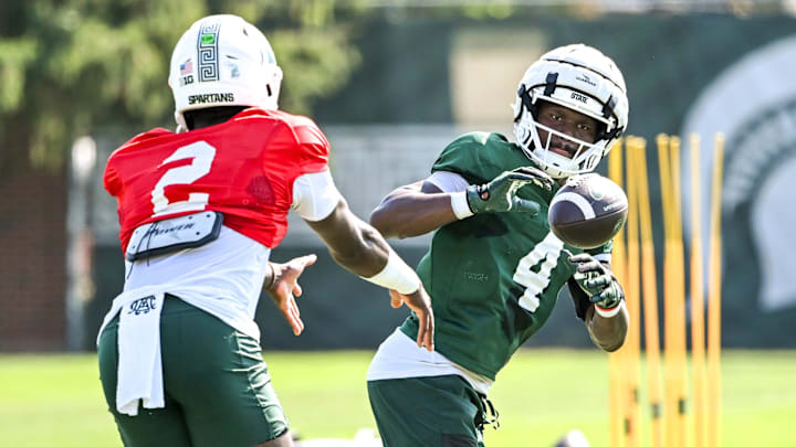 Michigan State running back Elijah Tau-Tolliver, right, gets a pitch from Aidan Chiles during football practice on Monday, Aug. 11, 2025, in East Lansing.