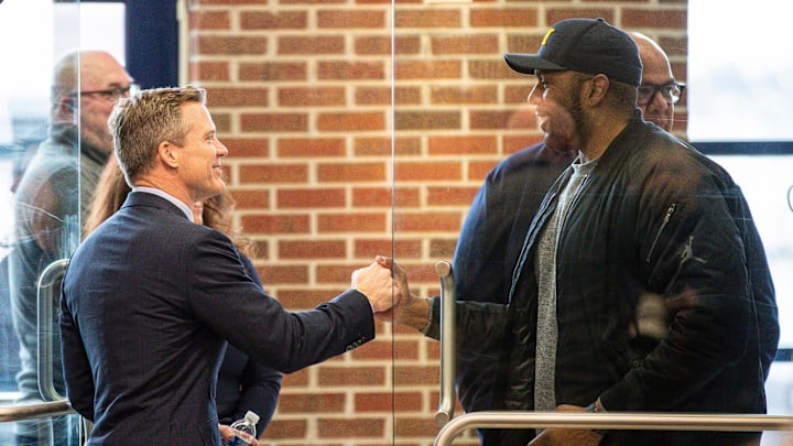 U-M's new men's basketball head coach Dusty May shakes hands with head football coach Sherrone Moore during an introductory press conference at Junge Family Champions Center in Ann Arbor on Tuesday, March 26, 2024.