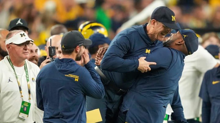 Michigan head coach Jim Harbaugh is lifted off the ground by offensive coordinator Sherrone Moore after Michigan won the College Football Playoff national championship game against Washington at NRG Stadium in Houston on Monday, Jan. 8, 2024.