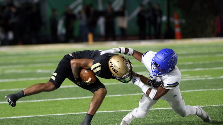 Elkhart senior Londyn Johnson, right, commits a facemask penalty while trying to tackle Penn junior Tayshon Bardo during a football game Friday, Oct. 4, 2024, at Penn High School in Mishawaka.b