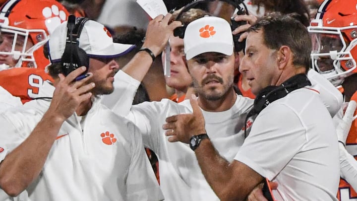 Sep 16, 2023; Clemson, South Carolina; Clemson head coach Dabo Swinney talks with Clemson wide receiver coach Tyler Grisham, left, and offensive coordinator Garrett Riley, middle, during the fourth quarter with Florida Atlantic at Memorial Stadium.  Mandatory Credit: Ken Ruinard-USA TODAY NETWORK