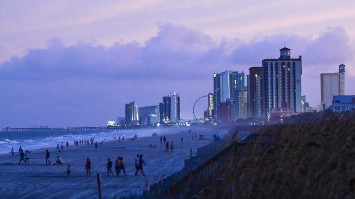 People walk and play along the shoreline near evacuated hotels along North Ocean Boulevard in Myrtle Beach, South Carolina Tuesday, Sept 3, 2019 when the Hurricane Dorian dawned.