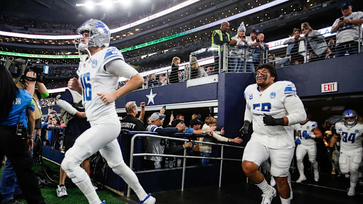 Detroit Lions offensive tackle Penei Sewell follows quarterback Jared Goff.