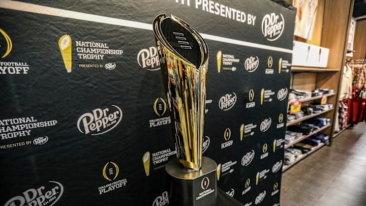 Fans stop to take photos with the College Football National Championship trophy at Meijer in Ypsilanti, Mich. on Thursday, Jan. 11, 2024. The trophy is going on a tour for fans to see presented by Dr. Pepper.