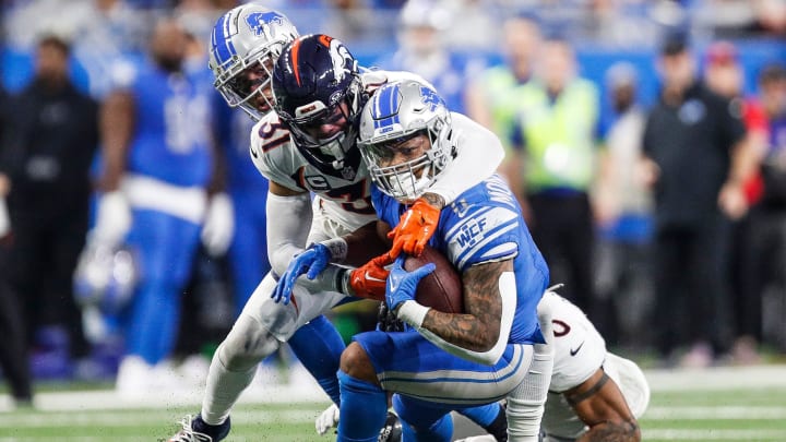 Detroit Lions running back David Montgomery runs against Denver Broncos safety Justin Simmons during the first half at Ford Field in Detroit on Saturday, Dec. 16, 2023.