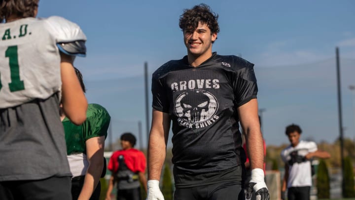 Avery Gach, 17, a junior at Birmingham Groves High School, smiles as he stands next to his teammate during a football practice in Beverly Hills on Tuesday, Oct. 24, 2023.