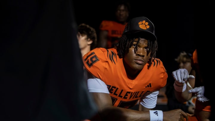 Belleville quarterback Bryce Underwood (19) looks up at one of his coaches as he kneels alongside his teammates after a 35-8 victory against Westland Glenn in Belleville on Friday, Sept. 29, 2023.