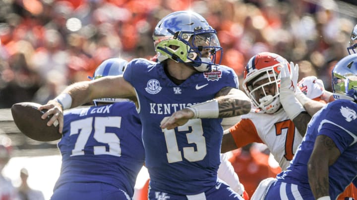 Kentucky quarterback Devin Leary (13) passes near Clemson defensive end Justin Mascoll (7) during the first quarter of the TaxSlayer Gator Bowl at EverBank Stadium in Jacksonville, Florida, Friday, December 29, 2023.