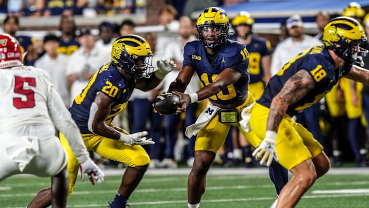 Michigan quarterback Alex Orji (10) hands the ball to Michigan running back Kalel Mullings (20) during the first half against Fresno State at Michigan Stadium at Michigan Stadium in Ann Arbor on Saturday, Aug. 31, 2024.