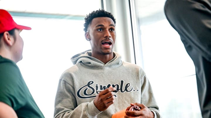 Michigan State basketball player Tyson Walker talks with fellow Spartan Malik Hall while signing autographs for fans during an event on Thursday, April 4, 2024, at the McDonald's on East Grand River Avenue near the MSU campus in East Lansing.