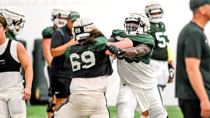 Michigan State's Rakeem Johnson, right, and Jacob Merritt run a drill during camp on Monday, Aug. 5, 2024, at the indoor practice facility in East Lansing.