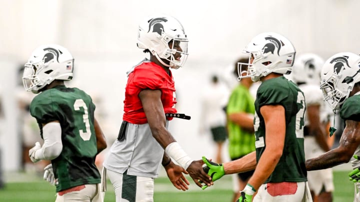 Michigan State's quarterback Aidan Chiles, center, slaps hands with teammates during camp on Monday, Aug. 5, 2024, at the indoor practice facility in East Lansing.