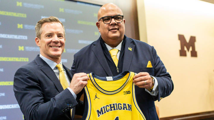 U-M athletic director Warde Manuel presents a jersey to new men's basketball head coach Dusty May during an introductory press conference for Dusty May at Junge Family Champions Center in Ann Arbor on Tuesday, March 26, 2024.