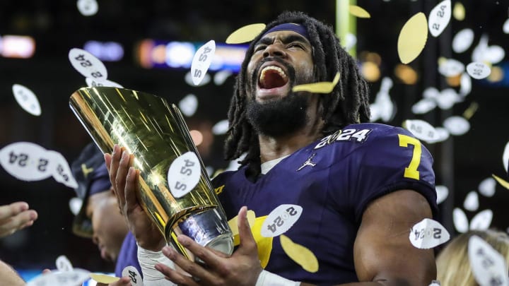 Michigan running back Donovan Edwards lifts the trophy to celebrate the 34-13 win over Washington in the national championship game at NRG Stadium in Houston on Monday, Jan. 8, 2024.