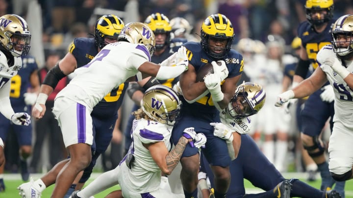 Michigan running back Kalel Mullings (20) is brought down by Washington defense in the second quarter during the College Football Playoff national championship game against Washington at NRG Stadium in Houston, Texas on Monday, January 8, 2024.