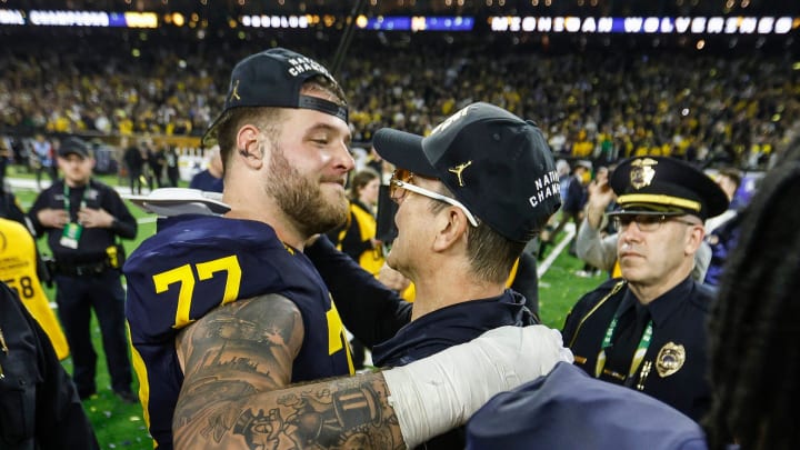 Michigan offensive lineman Trevor Keegan hugs coach Jim Harbaugh to celebrate the 34-13 win over Washington to win the national championship game at NRG Stadium in Houston on Monday, Jan. 8, 2024.