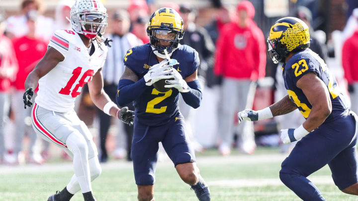 Michigan defensive back Will Johnson intercepts a pass intended for Ohio State wide receiver Marvin Harrison Jr. during the first half at Michigan Stadium in Ann Arbor on Saturday, Nov. 25, 2023.